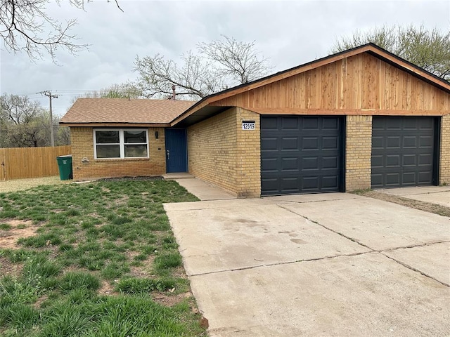 view of front facade with brick siding, driveway, and fence