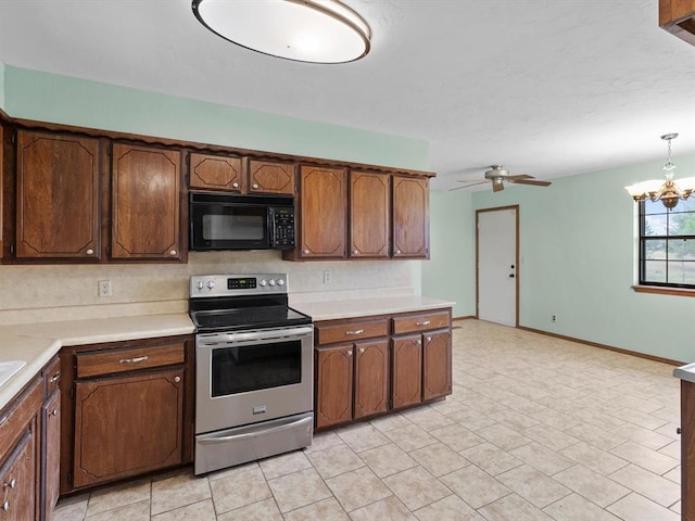 kitchen with light countertops, black microwave, baseboards, ceiling fan with notable chandelier, and electric range