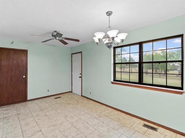 spare room with ceiling fan with notable chandelier, baseboards, and visible vents