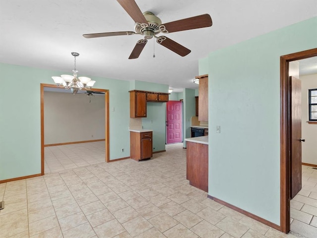 interior space featuring light countertops, baseboards, brown cabinets, black dishwasher, and ceiling fan with notable chandelier