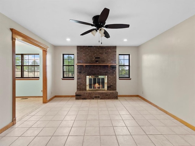 unfurnished living room featuring a ceiling fan, light tile patterned floors, baseboards, and a healthy amount of sunlight