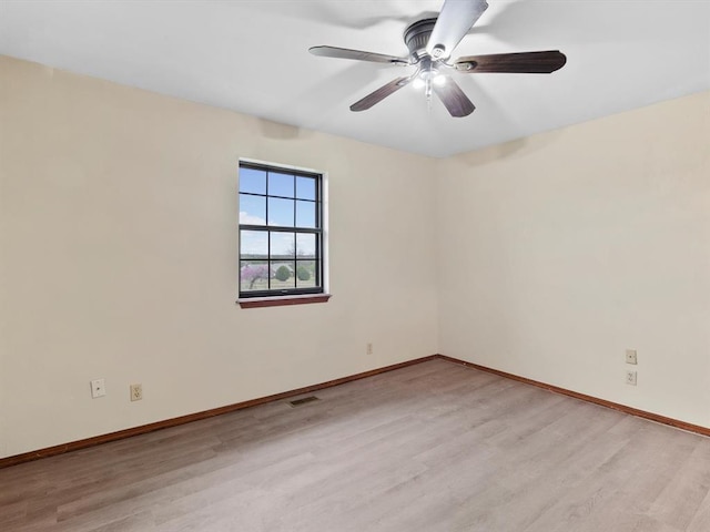 spare room with baseboards, visible vents, and light wood-style floors