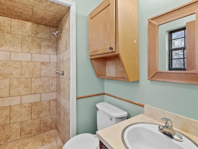 full bath with a stall shower, toilet, and vanity