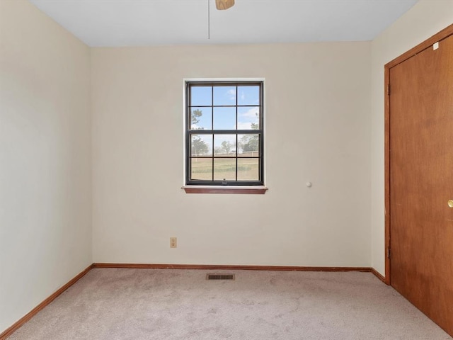 carpeted spare room featuring baseboards and visible vents
