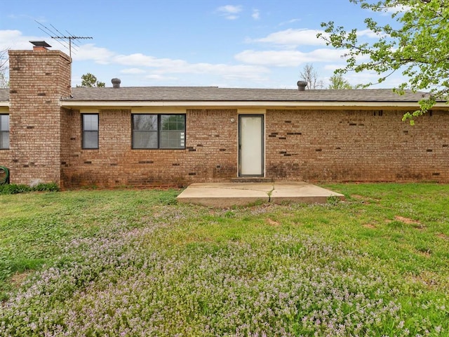 rear view of property featuring a chimney, crawl space, a yard, and a patio area