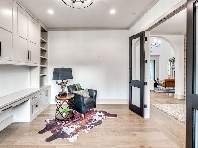 sitting room with arched walkways, recessed lighting, ornamental molding, and an inviting chandelier