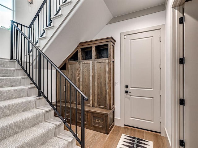 entryway featuring light wood-type flooring, baseboards, and stairway