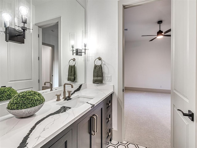 bathroom featuring baseboards, a ceiling fan, and vanity