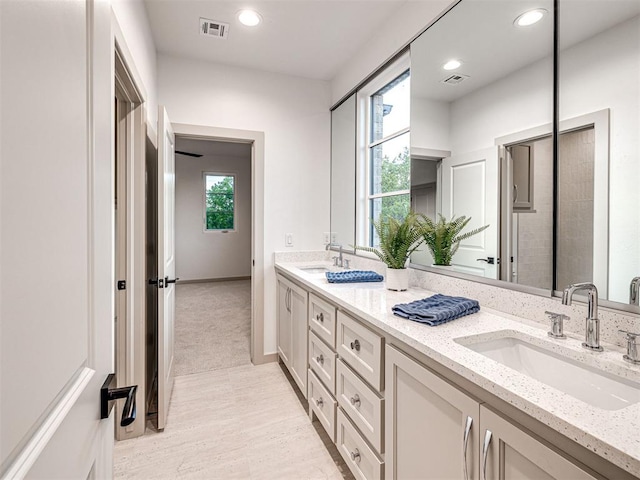 bathroom featuring double vanity, visible vents, wood finished floors, and a sink