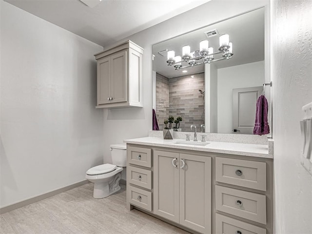 full bath with wood finished floors, vanity, a tile shower, toilet, and visible vents