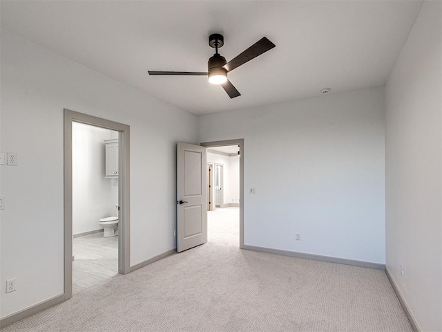 unfurnished room featuring light colored carpet, ceiling fan, and baseboards