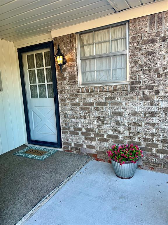 entrance to property featuring brick siding