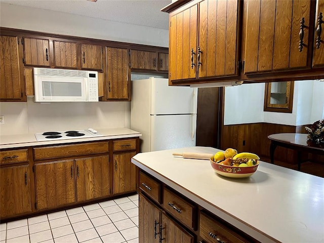 kitchen featuring white appliances, light countertops, and light tile patterned flooring