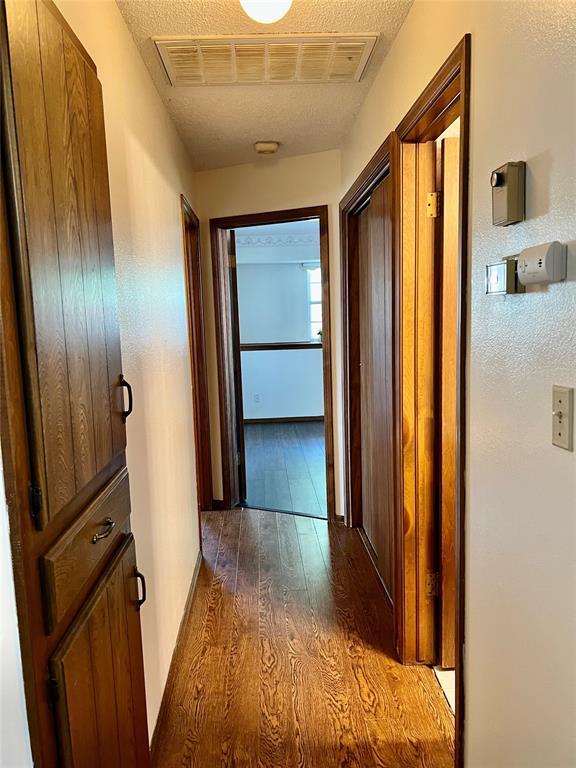 hall featuring dark wood-style floors and baseboards