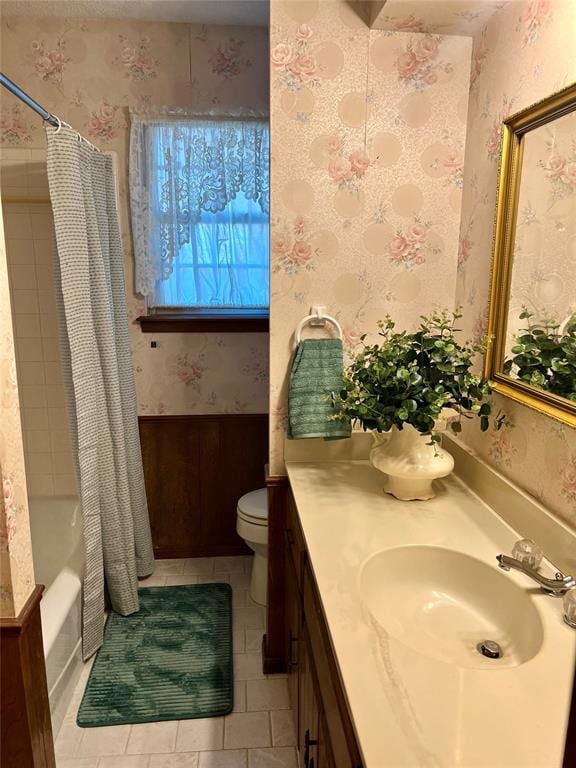 full bath with toilet, tile patterned floors, wallpapered walls, vanity, and shower / tub combo with curtain