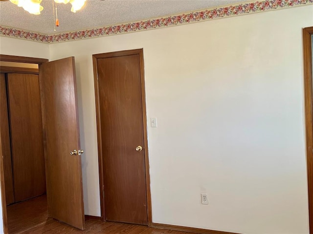 unfurnished bedroom featuring wood finished floors and baseboards