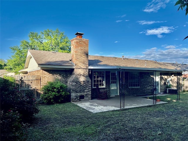 rear view of property with a chimney, a patio, and brick siding