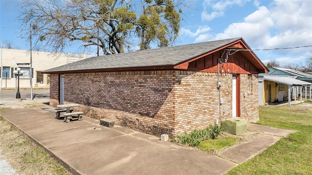 view of side of property featuring brick siding and a yard