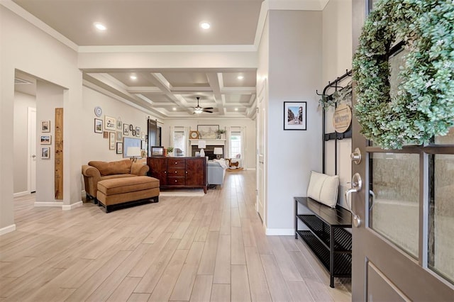 living area featuring light wood-style flooring, ceiling fan, baseboards, and a fireplace