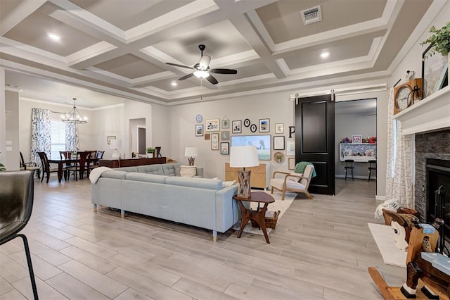 living room featuring visible vents, a stone fireplace, light wood-type flooring, ceiling fan with notable chandelier, and coffered ceiling