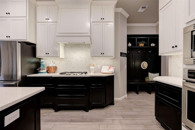 kitchen featuring stainless steel appliances, visible vents, white cabinets, and dark cabinets