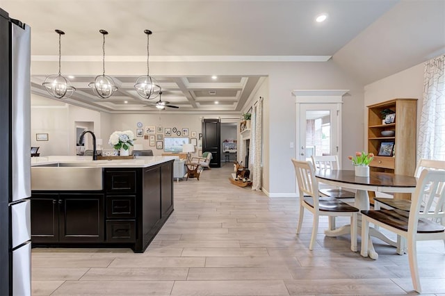 kitchen with baseboards, light countertops, dark cabinetry, light wood-style floors, and coffered ceiling