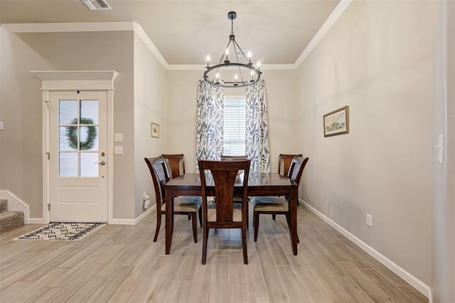 dining room featuring a chandelier, light wood finished floors, baseboards, and stairs