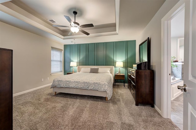 bedroom featuring visible vents, baseboards, a raised ceiling, and light carpet