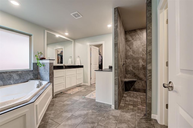 bathroom featuring vanity, recessed lighting, a walk in shower, visible vents, and a bath