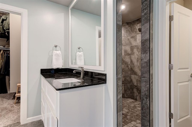 bathroom with a walk in closet, a walk in shower, and vanity