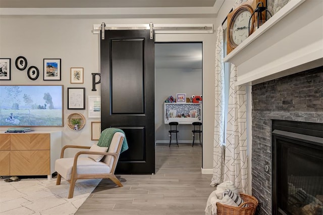 sitting room featuring a fireplace, light wood-style floors, and baseboards