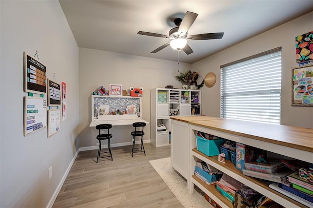 office area with ceiling fan, light wood-type flooring, and baseboards