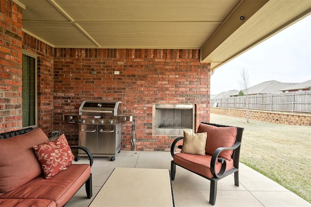 view of patio / terrace featuring an outdoor living space with a fireplace, a grill, and fence