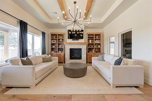 3824 Stone Hill Ln, Edmond, OK 73034 - living area with a chandelier, a fireplace, wood finished floors, and a raised ceiling
