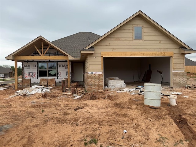 view of front of house with brick siding, a shingled roof, and a garage