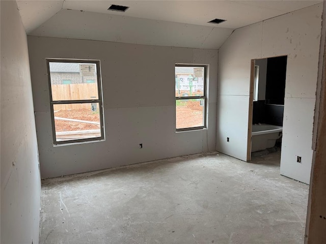 unfurnished bedroom with vaulted ceiling and visible vents