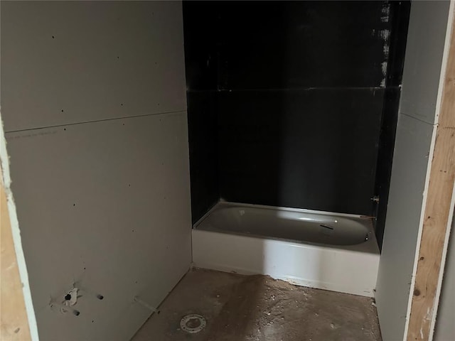 bathroom featuring unfinished concrete floors and a tub