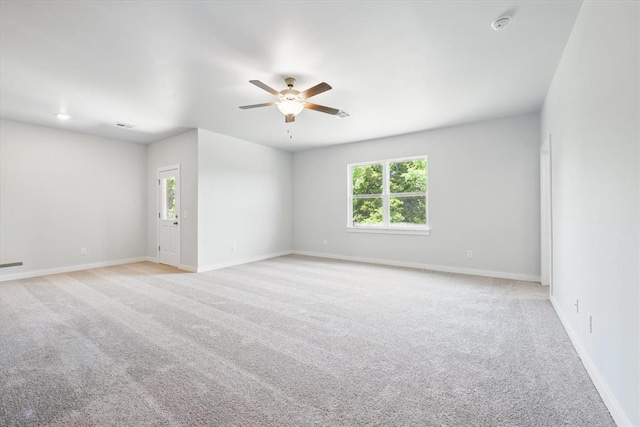 unfurnished room with plenty of natural light, baseboards, ceiling fan, and light carpet