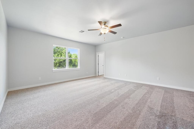 unfurnished room with a ceiling fan, baseboards, visible vents, and light carpet