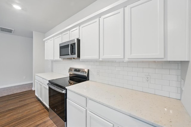 kitchen with visible vents, tasteful backsplash, baseboards, stainless steel appliances, and white cabinetry