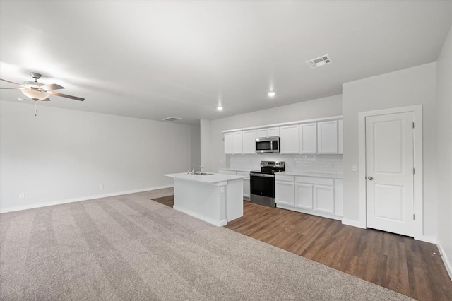 kitchen featuring visible vents, appliances with stainless steel finishes, a sink, open floor plan, and carpet