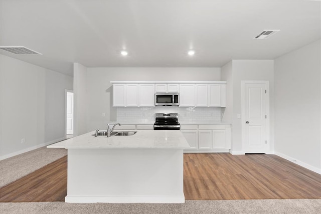 kitchen featuring visible vents, white cabinets, tasteful backsplash, a sink, and stainless steel appliances