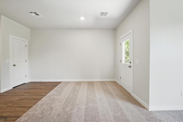 empty room featuring baseboards, recessed lighting, carpet floors, and visible vents