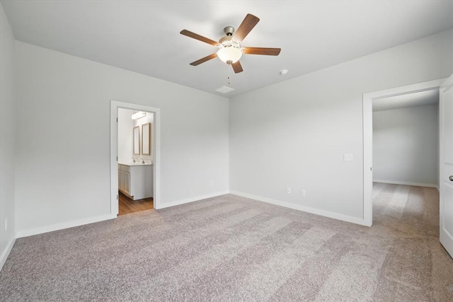 unfurnished bedroom featuring ceiling fan, a sink, baseboards, connected bathroom, and carpet flooring