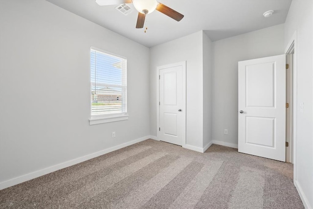 unfurnished bedroom featuring baseboards, light carpet, and visible vents