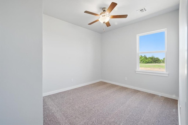 carpeted empty room with ceiling fan, visible vents, and baseboards