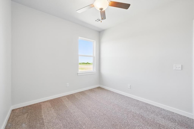 carpeted empty room featuring baseboards, a ceiling fan, and visible vents