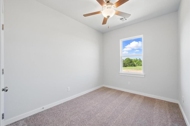 carpeted empty room with baseboards, a ceiling fan, and visible vents
