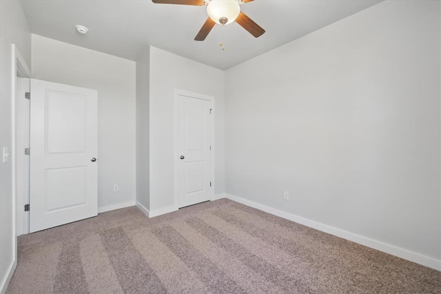 unfurnished bedroom with carpet floors, baseboards, and a ceiling fan