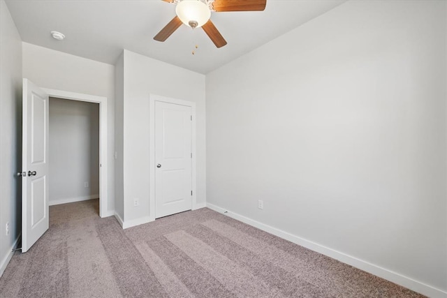 unfurnished bedroom featuring a ceiling fan, baseboards, and light carpet
